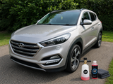 Nerta Hydro Ceramic Wax concentrate with foam lance and microfibre cloth beside vehicle ready for ceramic protection treatment