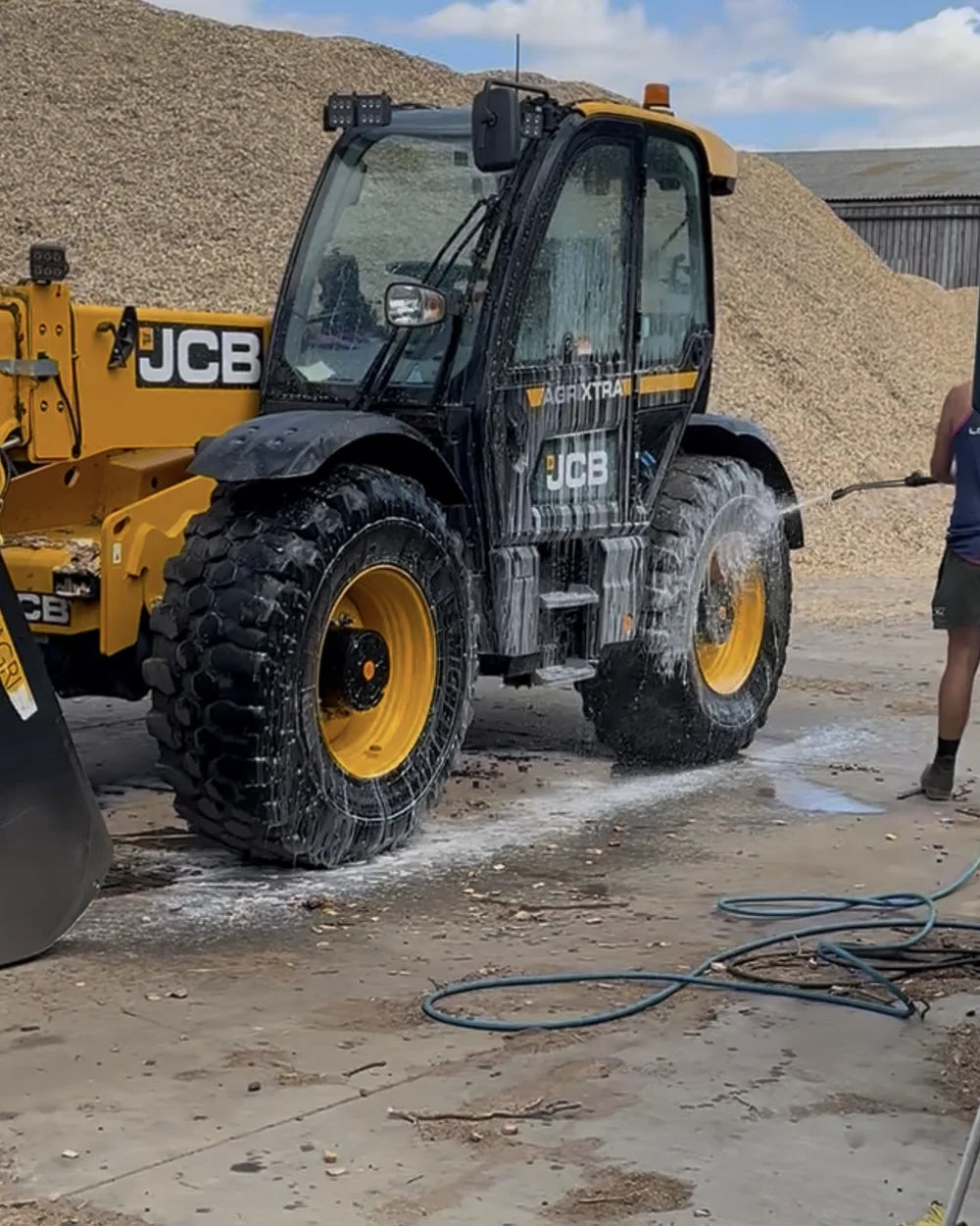 Thin streaks of foam on a JCB telehandler during a farm wash setup visit.
